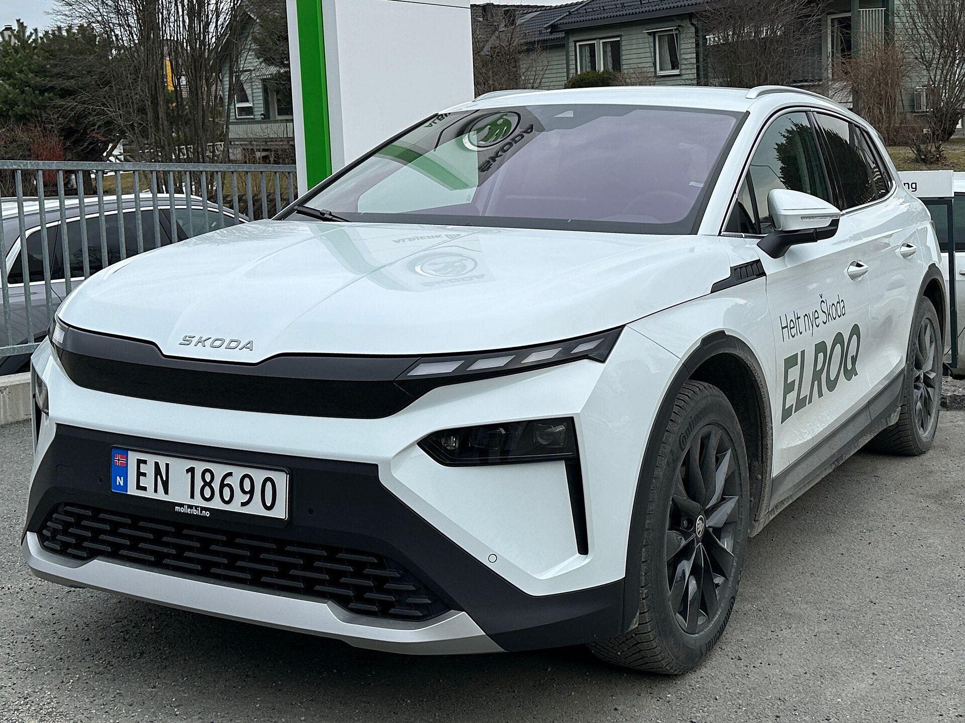 Škoda Elroq beyaz, şarj istasyonunda önden üç çeyrek görünüm