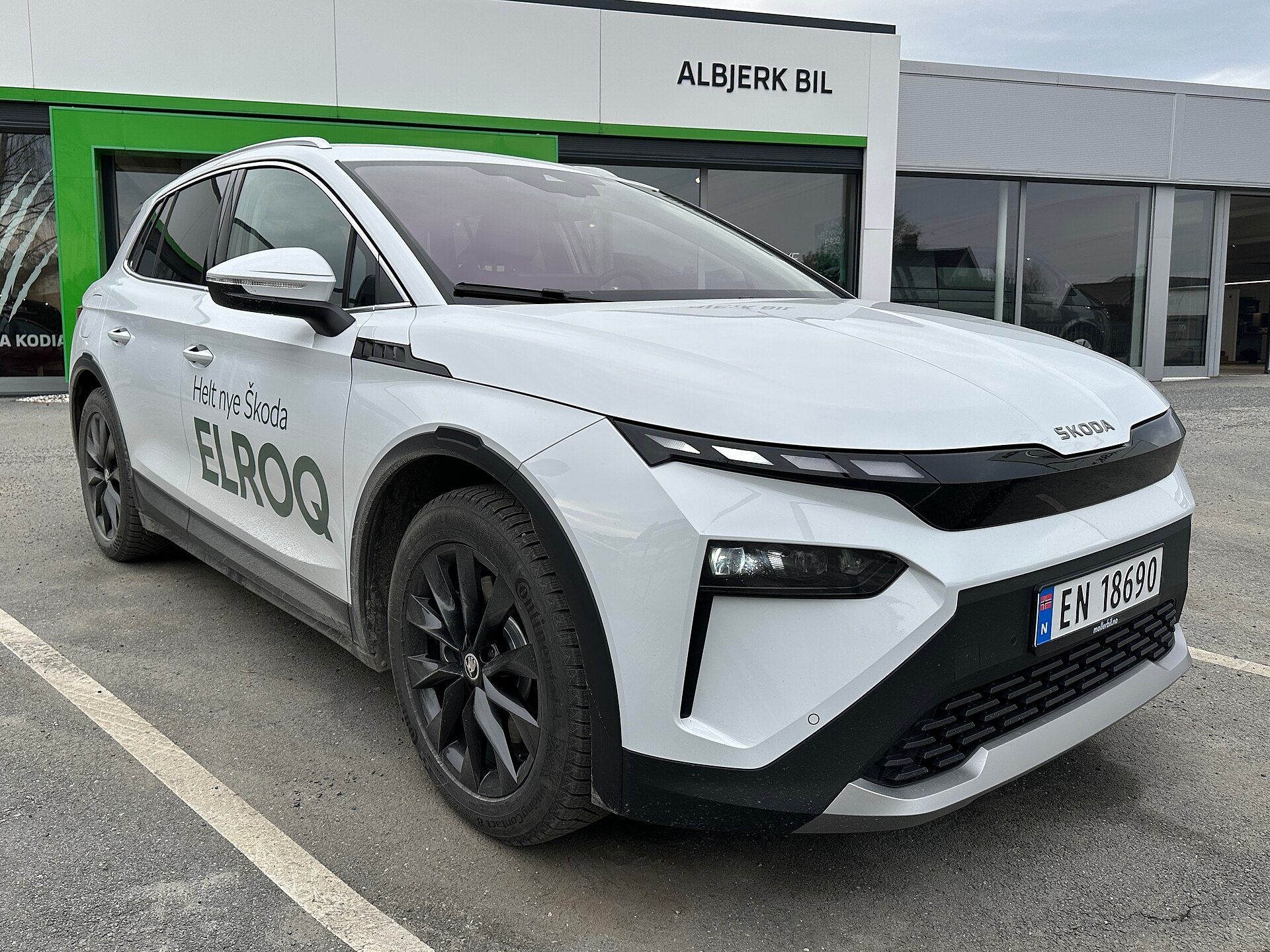 Škoda Elroq beyaz, bayi önünde yandan-önden görünüm