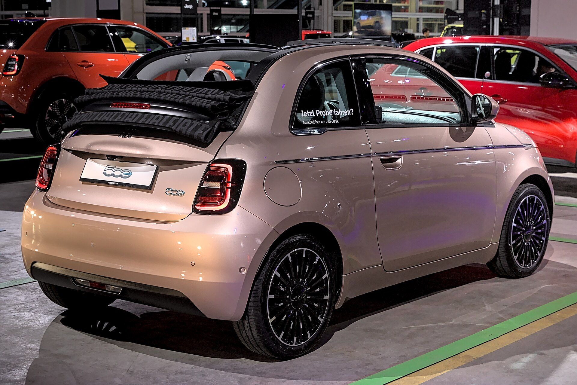 Roze altın Fiat 500e Cabrio, tavanı açık arka görünüm (Auto Zürich 2023)