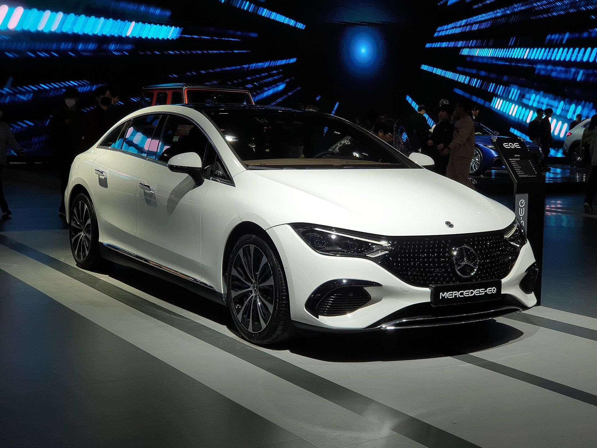Beyaz Mercedes-Benz EQE 350+, fuar standında ön çapraz görünüm