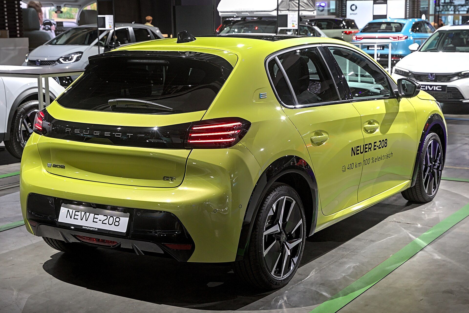 Sarı Peugeot E-208 (makyajlı), arka çapraz görünüm ve yeni LED stop şeridi